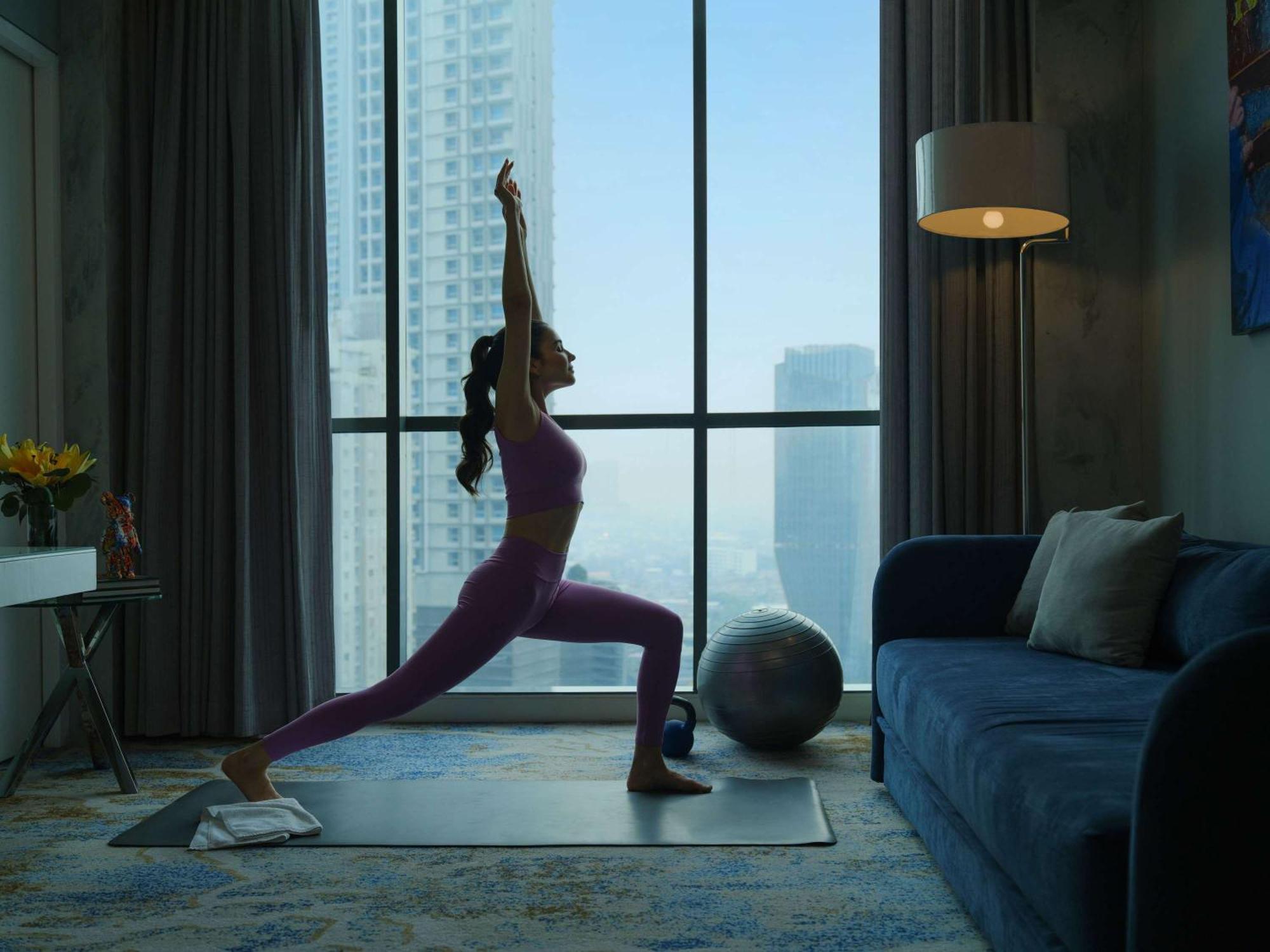 Pullman Jakarta Central Park Exteriör bild A woman practicing yoga at home